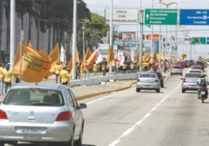 Ontem, desde cedo, pessoas balançando bandeiras do candidato Camilo Santana tomaram parcialmente a Avenida Washington Soares na Capital cearense